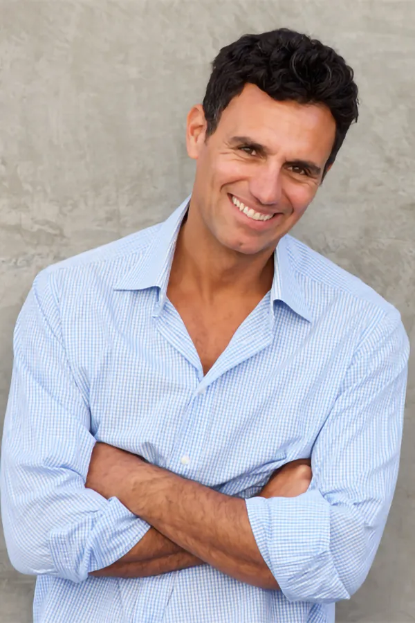 Acoustic-Pressure-Wave-for-ED-Treatment A middle-aged man with dark hair leans against a wall with his arms folded confidently. Get Acoustic Pressure Wave for Erectile Dysfunction treatment from Regenerative Medical Institute in Greenville.
