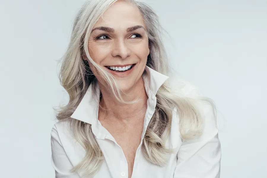 Forma-Skin-Rejuvenation-Clinic Older woman with long grey hair smiling from receiving Forma Skin Rejuvenation from Regenerative Medical Institute in Greenville.