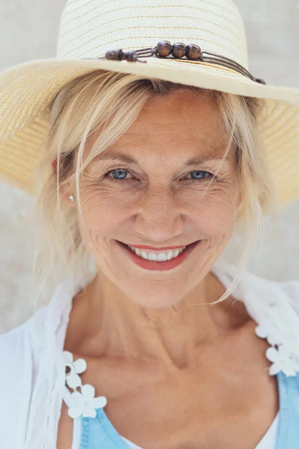 Menopause-Treatment A beautiful, smiling older woman with blonde hair and a sunhat, happy with menopause treatment from Regenerative Medical Institute in Greenville.