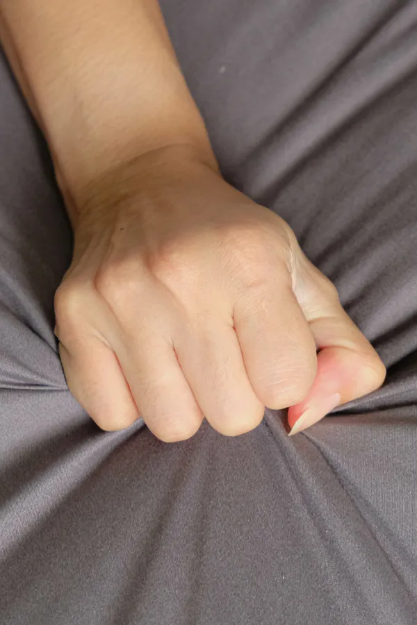 PRP-O-Shot-Treatment A close up of a woman's hand grabbing a gray bed sheet suggestively, representing successful O-Shot treatment for sexual wellness from Regenerative Medical Institute in Greenville.