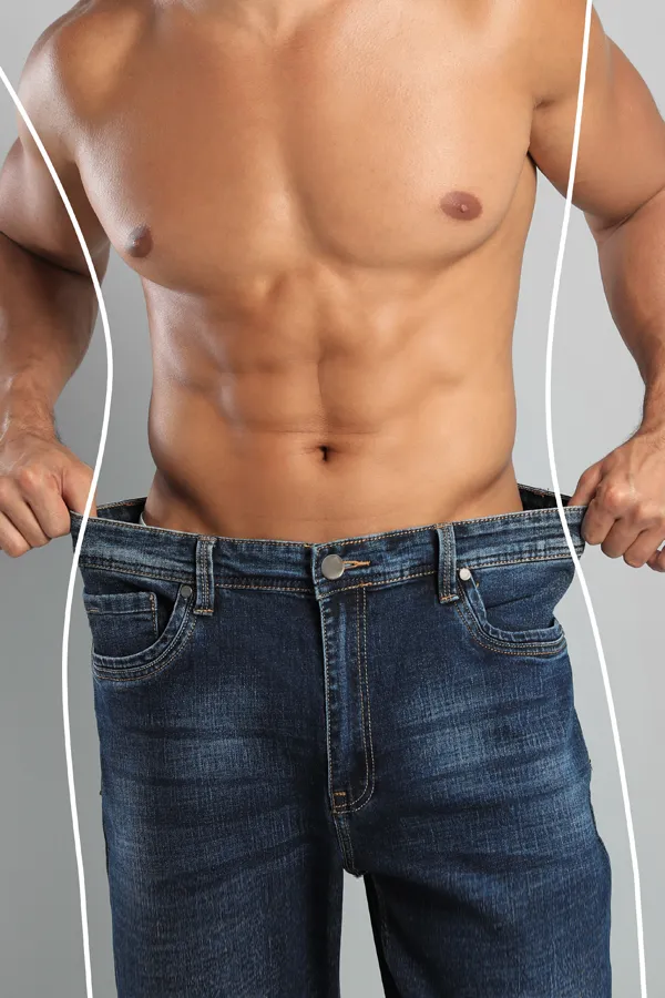 Semaglutide-Weight-Loss-Treatment A strong shirtless man in jeans holds the waistlines of his too-big jeans to show the success of semaglutide weight loss from Regenerative Medical Institute in Greenville.